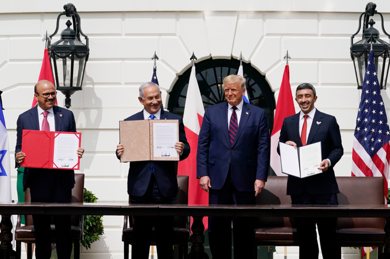 도널드 트럼프 미국 대통령이 지난 2020년 9월15일 백악관 잔디밭에서 바레인 외교부 장관 압둘라티프 빈 라시드 알자야니(왼쪽 첫 번째), 베냐민 네타냐후 이스라엘 총리(왼쪽 두 번째), 아랍에미리트 외교부 장관 압둘라 빈 자이드 알 나하얀(오른쪽)이 참석한 가운데 이스라엘과 이들 중동국가가 국교정상화에 합의하는 내용의 ‘아브라함 협정’에 서명한 후 들어보이며 활짝 웃고 있다.