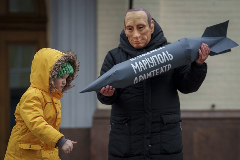 러시아 대선 마지막 날인 17일(현지시간) 우크라이나 수도 키이우에서 한 시민이 블라디미르 푸틴 러시아 대통령의 가면을 쓰고 '마리우폴 드라마 극장'이라는 글귀가 적힌 종이 폭탄 모형을 든 채 시위하고 있다. 이날 키이우에는 수백명이 모여 러시아가 점령한 우크라 남부 마리우폴에 붙잡혀 있는 우크라 포로들이 집으로 돌아와야 한다고 주장했다.AP뉴시스