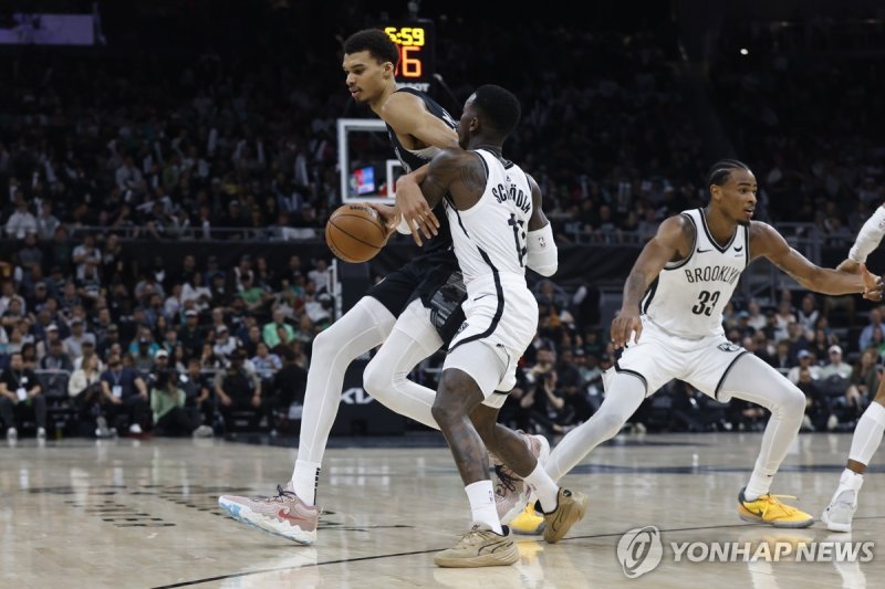 브루클린 전에서 공격을 시도하는 샌안토니오 웸반야마(왼쪽) epa11227313 San Antonio Spurs center Victor Wembanyama of France (L) dribbles past Brooklyn Nets guard Dennis Schroder of Germany (C) during the second half of an NBA game between the San Antonio Spurs and the Brooklyn Nets in Austin, Texas, USA, 17 March 2024. EPA/A