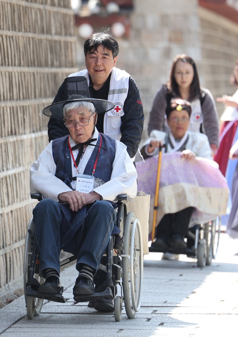 한복을 입은 사할린 동포들이 18일 문화체험을 위해 서울 경복궁으로 향하고 있다. 대한적십자사는 코로나19와 러시아-우크라이나 전쟁으로 일시 중단됐던 '사할린 동포 일시 모국 방문 지원사업'을 4년 만에 재개했다. 이들은 1990년 러사아와 수교가 체결되면서 동포들이 국내 영주귀국할 수 있었으나 자녀 등 가족과 이산 문제로 영주귀국을 포기하고 현지에 남기로 한 동포들이다. 동포들은 오는 23일까지 국내에 체류하며 형제자매 등 가족과 만나는 시간을 갖고 청와대 등을 방문하며 한국문화를 체험 할 예정이다. 2024.3.18/뉴스1 ⓒ 