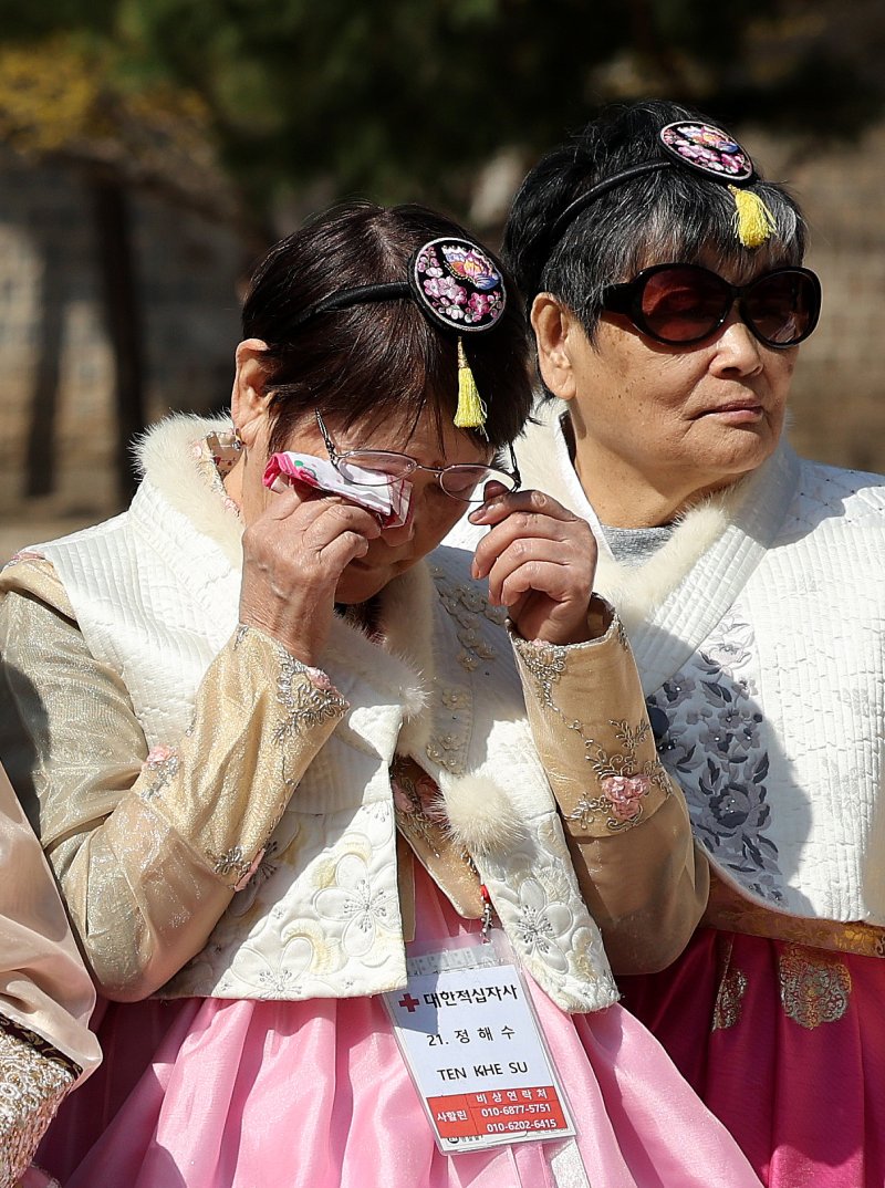 한복을 입은 사할린 동포가 18일 서울 경복궁에서 기념촬영 중 감격의 눈물을 닦고 있다. 대한적십자사는 코로나19와 러시아-우크라이나 전쟁으로 일시 중단됐던 '사할린 동포 일시 모국 방문 지원사업'을 4년 만에 재개했다. 이들은 1990년 러사아와 수교가 체결되면서 동포들이 국내 영주귀국할 수 있었으나 자녀 등 가족과 이산 문제로 영주귀국을 포기하고 현지에 남기로 한 동포들이다. 동포들은 오는 23일까지 국내에 체류하며 형제자매 등 가족과 만나는 시간을 갖고 청와대 등을 방문하며 한국문화를 체험 할 예정이다. 2024.3.18/뉴스