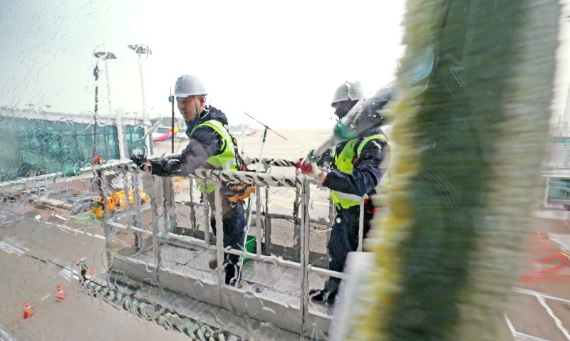 인천공항운영서비스 환경미화운영그룹 직원들이 19일 오전 인천국제공항 제1터미널에서 봄맞이 유리창 물청소를 하고 있다. 2024.3.19/뉴스1 ⓒ News1 장수영 기자