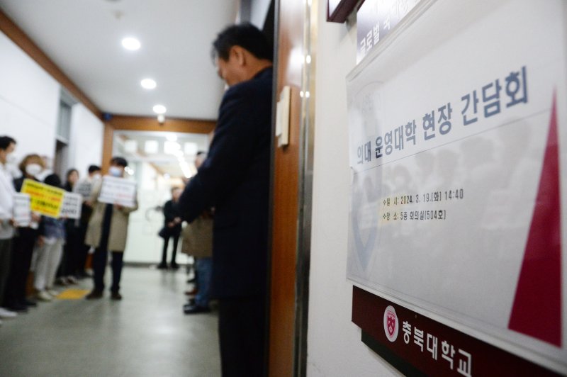 [청주=뉴시스] 조성현 기자 = 지난 19일 오후 충북 청주시 서원구 개신동 충북대학교 대학본부 건물 앞에서 정부의 의과대학 증원 정책에 반대하는 이 대학 의과대학과 대학병원 교수회 비상대책위원회 관계자들이 의대 운영대학 현장 간담회가 열리는 회의실 앞에서 피켓 시위를 하고 있다. 2024.03.19. jsh0128@newsis.com