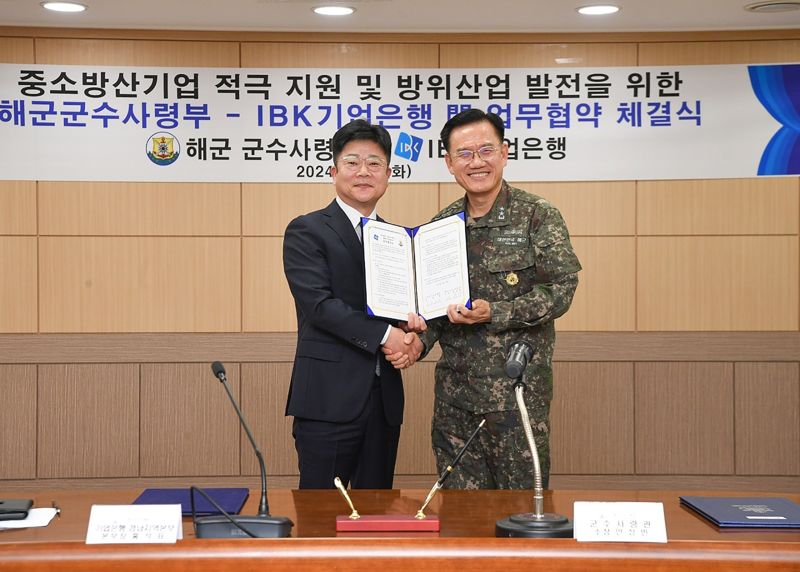 홍석표 IBK기업은행 경남지역본부 본부장(왼쪽)과 안상민 해군군수사령부 사령관이 지난 19일 해군군수사령부에서 열린 업무협약식에서 기념촬영을 하고 있다. IBK기업은행 제공