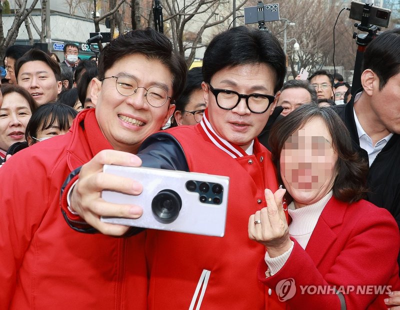 국민의힘 한동훈 비상대책위원장과 조정훈 후보(마포 을)가 19일 서울 마포구 경의선숲길에서 지지자들과 기념촬영을 하고 있다. 연합뉴스