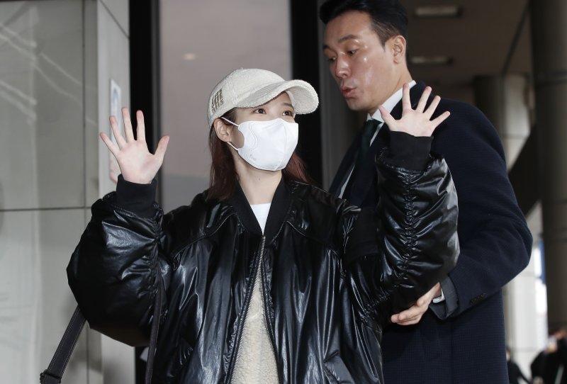 가수 아이유가 해외 일정을 위해 22일 김포공항을 통해 일본 도쿄로 출국하며 인사를 하고 있다. 옆에는 그의 든든한 경호원이 잘못된 동선으로 이동하는 아이유의 방향을 체크해 주고 있다. ⓒ News1 권현진 기자