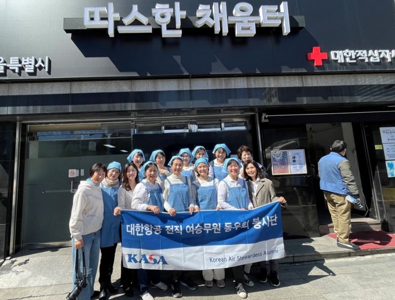 지난 21일 서울역 무료급식소인 '따스한채움터'에서 봉사활동에 나선 대한항공 전직 여승무원동우회 카사(KASA) 회원들이 기념촬영을 하고 있다.