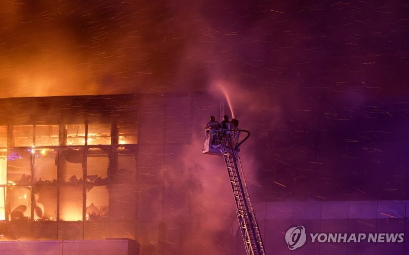 진화 중인 소방대원 Rescuers work to extinguish fire at the burning Crocus City Hall concert venue following a shooting incident, outside Moscow, Russia, March 22, 2024. REUTERS/Maxim Shemetov