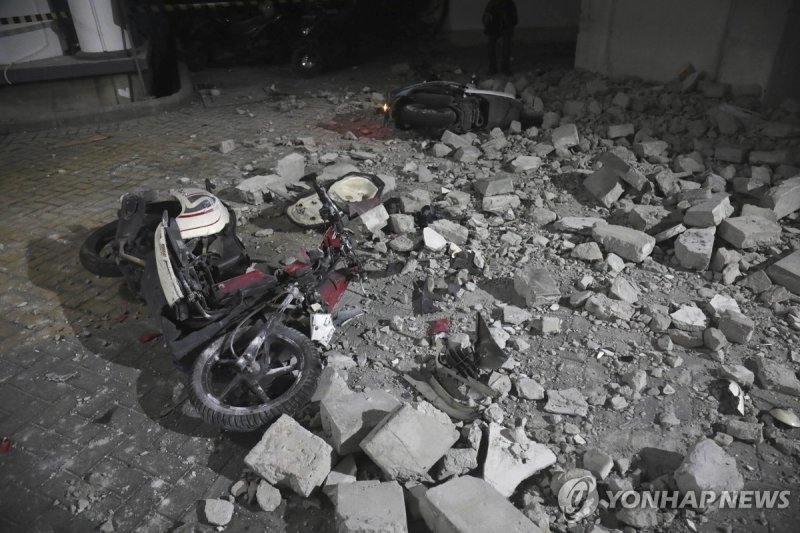 22일(현지시간) 인도네시아 자바해에서 발생한 지진으로 항구 도시 수라바야 거리의 벽이 무너져 오토바이가 쓰러져 있다. 연합뉴스