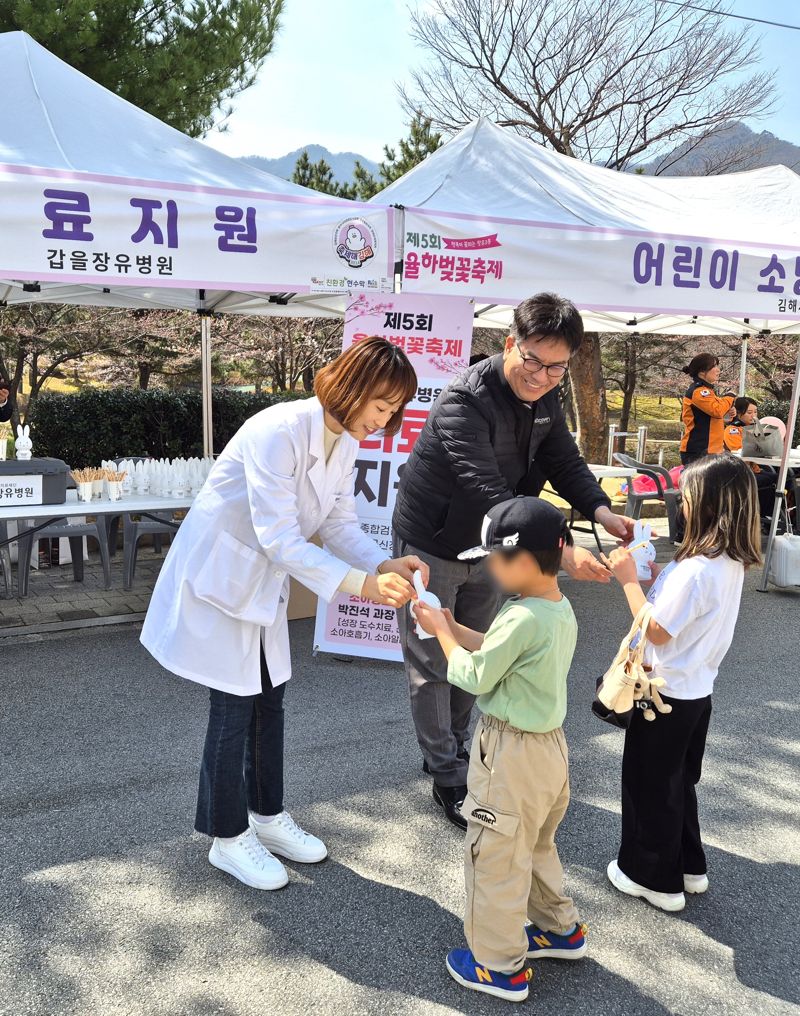 갑을장유병원 관계자들이 어린이들에게 토끼저금통과 볼펜을 선물하고 있다. 병원 제공
