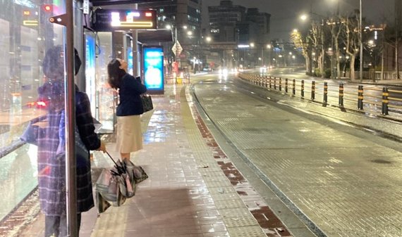28일 오전 5시경 비 내리는 서울 시내 한 정류장에서 승객들이 오지 않는 버스를 기다리고 있다. 사진=김경수 기자