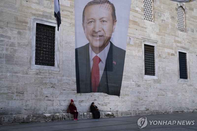 이스탄불 거리에 걸린 레제프 타이이프 에르도안 튀르키예 대통령 현수막 Two women sit near a campaign banner of Turkish President and leader of the Justice and Development Party, or AKP, Recep Tayyip in Istanbul, Turkey, Monday, March 11, 2024. Turkey was coming to terms on Monday with the opposition's unexpected success in local e