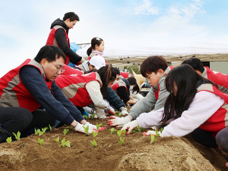 지난 3월 30일 서울 강서구 개화동에서 롯데건설 임직원 및 자녀들이 친환경 텃밭을 조성하고 있다. 롯데건설 제공