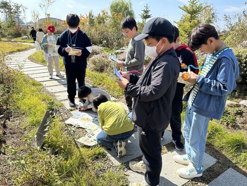 국립세종수목원에서 운영하는 초등대상 교육 프로그램인 `지구를 지키는 나침반`에 참여한 초등학생들이 식물을 관찰하고 있다.