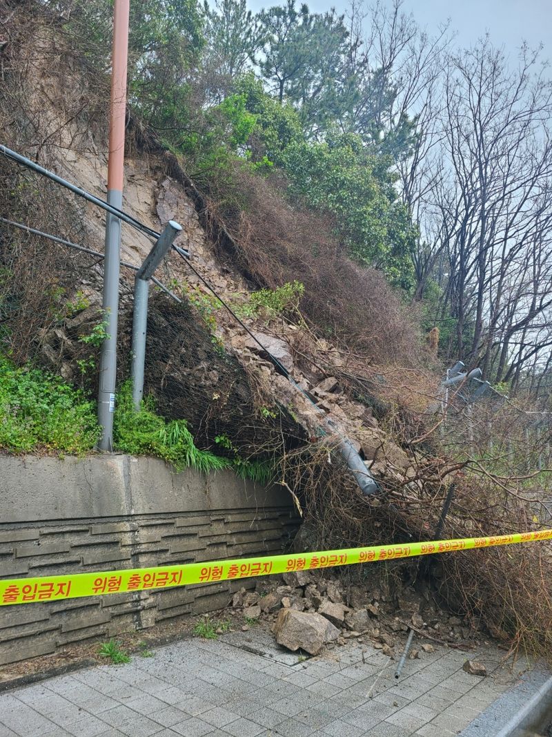 3일 오후 해운대구 송정동 성정어귀삼거리에서 달맞이교로 가는 도로의 우측 산비탈 일부가 무너졌다. 부산경찰청 제공
