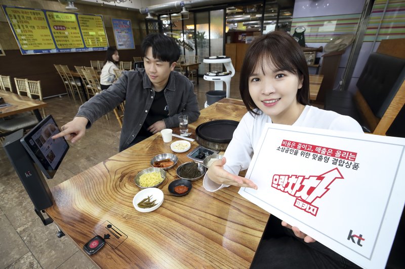 KT 모델이 서울 종로구의 한 음식점에서 KT 으랏차차 패키지에 포함된 하이오더와 AI 서빙로봇을 소개하고 있다. KT 제공