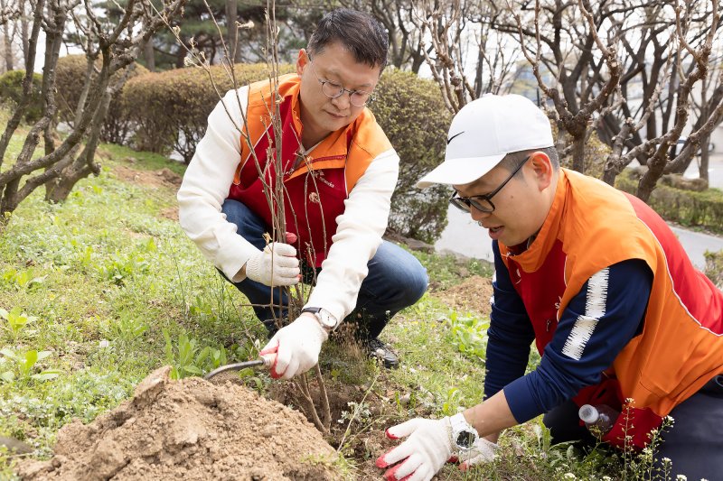 이호정 SK네트웍스 대표이사 사장(왼쪽)이 지난 5일 식목일을 맞아 서울 중구 남산공원에서 관계자와 무궁화 묘목 식재를 하고 있다. SK네트웍스 제공