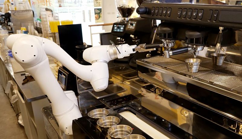 두산로보틱스 협동로봇이 원두가 담긴 포터필터를 커피머신에 장착하고 있다. 두산로보틱스 제공