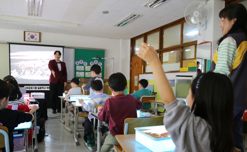 지난 5일 경기도 성남시 분당구 수내초등학교에서 샌드아트 전문강사와 KB금융 직원들이 1학년 학생들에게 '늘봄학교 샌드아트 체험 수업'을 진행했다. 사진=KB금융 제공