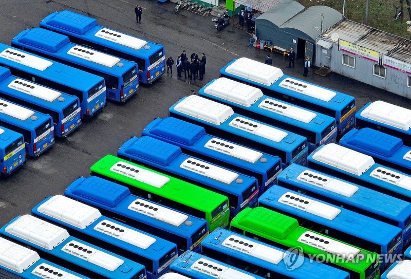 서울 시내버스 총파업이 시작된 3월28일 서울의 한 공영 차고지에 주차된 버스들 사이로 기사들이 모여 이야기를 나누고 있다. <연합뉴스>