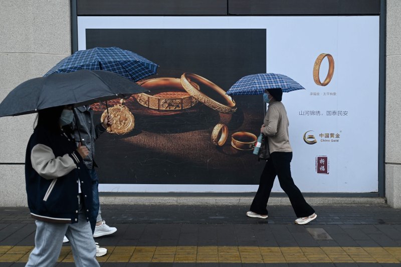 베이징 시민들이 10일 금 장식품을 선전한 대형 간판앞을 지나가고 있다. AFP 연합뉴스