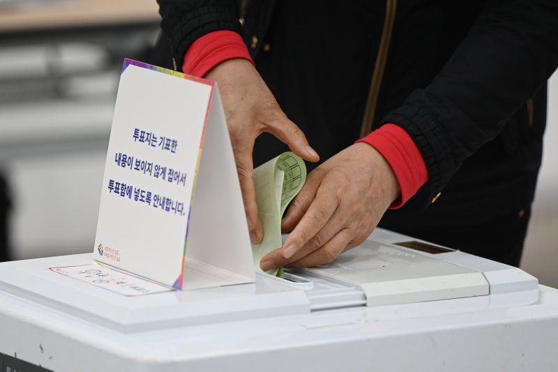 [광주=뉴시스] 박기웅 기자 = 제22대 국회의원 선거일인 10일 오전 광주 북구 우산동제1투표소(우산동주민센터)에서 한 유권자가 투표용지를 투표함에 넣고 있다. 2024.04.10. pboxer@newsis.com