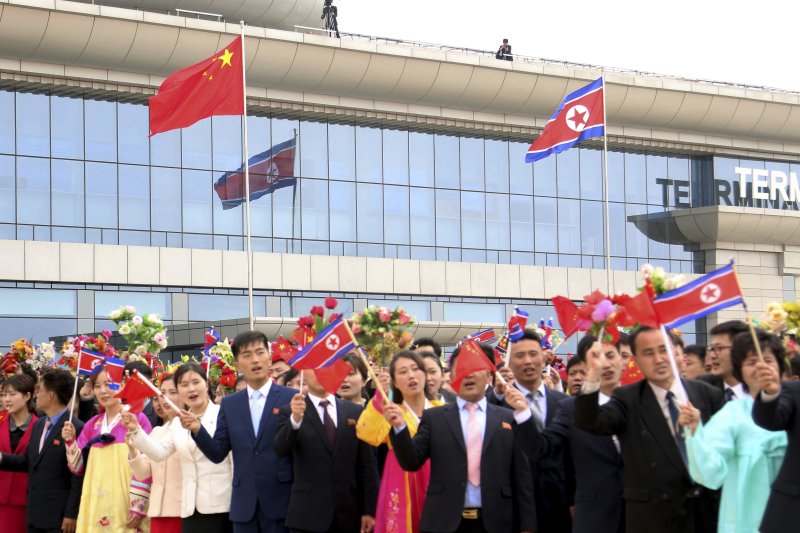 평양 시민들이 11일 평양 순안공안에 도착한 자오러지 중국 전인대 상무위원장을 환영하면서 북한 국기와 중국 오성홍기를 함께 흔들고 있다. AP 연합뉴스