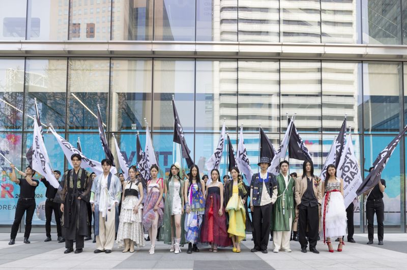 12일 청계천 일대에서 깃발 퍼포먼스 및 한복 패션쇼에 참가한 모델들이 '하이커 그라운드' 앞에서 단체 기념촬영을 하고 있다. 한국관광공사 제공