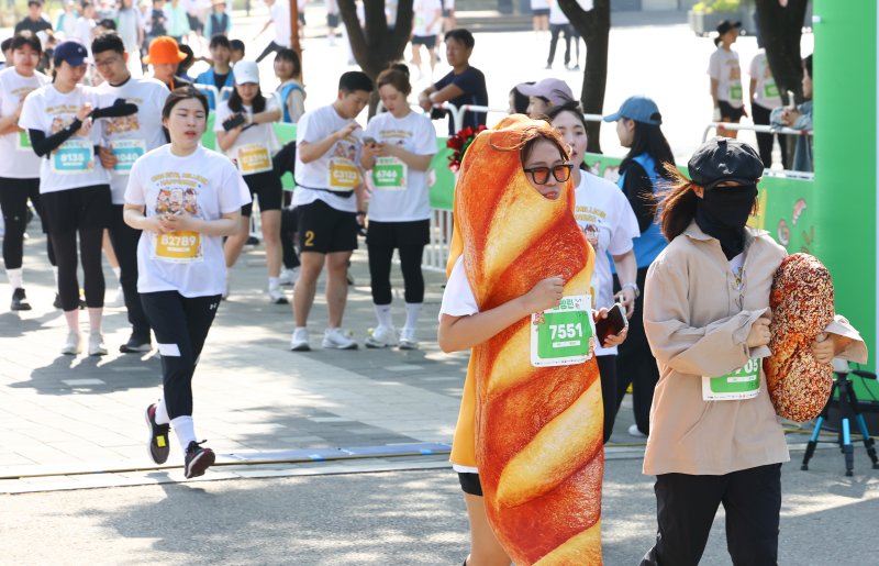 [서울=뉴시스] 황준선 기자 = 14일 오전 서울 마포구 평화의공원에서 열린 '빵빵런'에서 이색 복장의 참가자들이 힘차게 달리고 있다. 2024.04.14. hwang@newsis.com