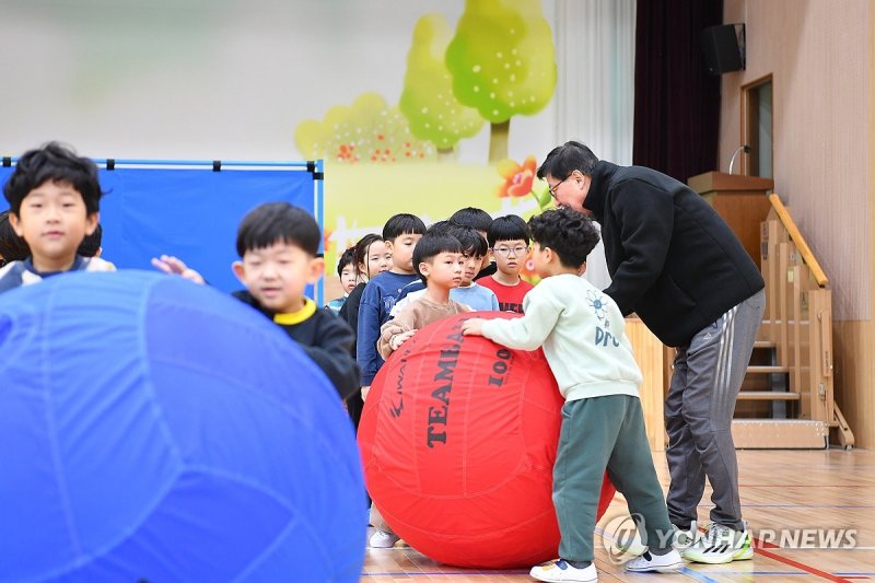 지난 3월 13일 부산 사하구 괴정초등학교 강당에서 박형준 부산시장이 늘봄학교에 참여하는 1학년 학생 20여 명과 공놀이를 하면서 재능기부 활동을 펼치고 있다. 연합뉴스 제공