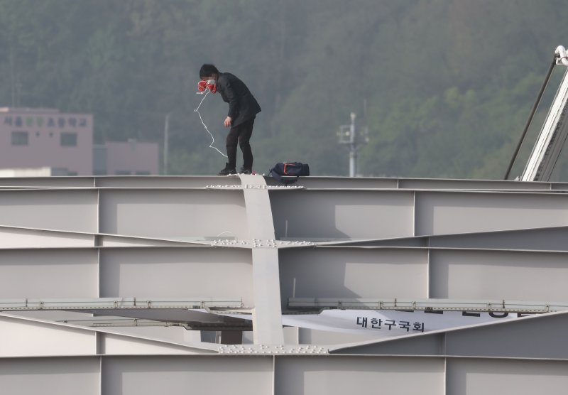 신원불명의 남성이 17일 오전 서울 용산구 한강대교 아치 위에 올라가 있다./사진=연합뉴스