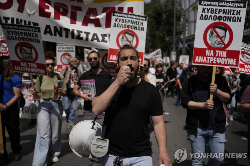 그리스 아테네서 고물가 항의 시위 A protester using a loudspeaker shouts slogans during a rally in Athens, Greece, Wednesday, April 17, 2024. A 24-hour strike called by Greece's largest labor union have halted ferries and public transport services in the Greek capital and other cities, to press for a return of col