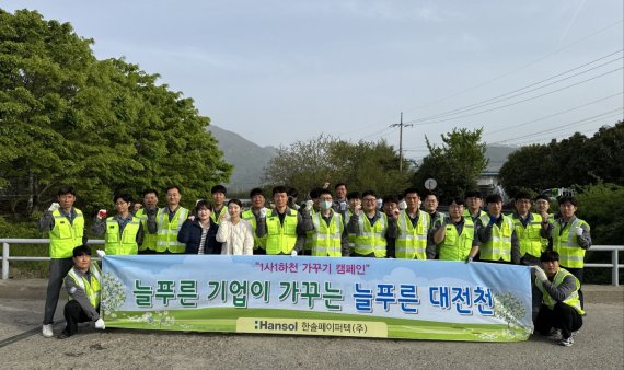 최근 한솔페이퍼텍 임직원 50여명은 대전천 주변에서 지역 환경 개선을 위한 캠페인 행사를 진행한 뒤 기념촬영을 하고 있다. 한솔페이퍼텍 제공