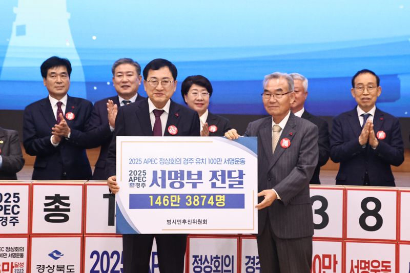 박몽룡 APEC경주유치범시민추진위원장(오른쪽)이 주낙영 경주시장에게 100만 서명운동 서명부를 전달하고 있다. 경주시 제공