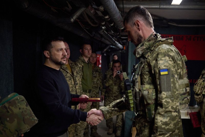 우크라이나의 볼로디미르 젤렌스키 대통령(왼쪽)이 19일(현지시간) 동부 도네츠크주 전선을 방문해 병사와 악수하고 있다.AFP연합뉴스