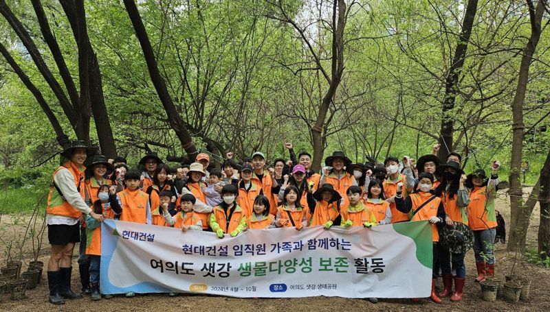 지난 20일 서울 영등포구 여의도 샛강생태공원 일대에서 열린 환경 보전을 위한 사회공헌활동에서 현대건설 임직원·가족 등이 기념촬영을 하고 있다. 현대건설 제공