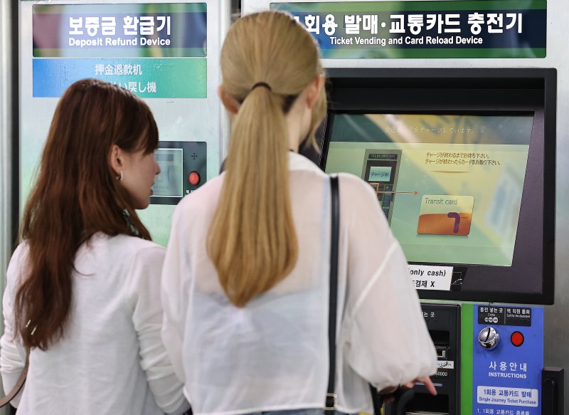 서울시는 기후동행카드의 신용·체크카드 충전 서비스를 개시한다고 21일 밝혔다. 서울 지하철 1호선 서울역에서 외국인 관광객들이 1회용 승차권을 구매하고 있다. 뉴스1