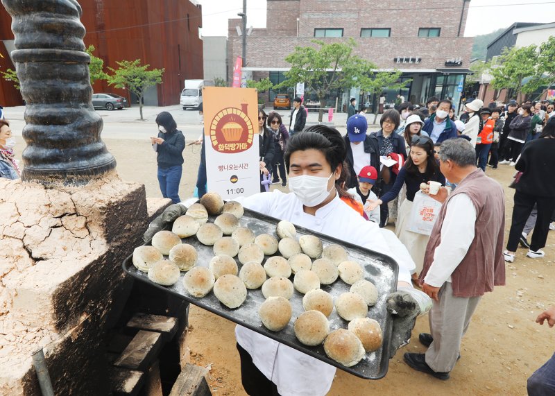 30일 경기 이천시 신둔면 예스파크와 사기막골 도예촌에서 열린 제37회 이천도자기축제를 찾은 관람객들이 화덕빵가마 무료시식행사에 참여하고 있다. 코로나19 팬데믹 이후 4년 만에 정상화한 이번 축제는 '삼시 세끼의 품격'이라는 주제 아래 이천 도자기를 대표하는 6개 마을의 240여개 공방이 참여해 역대 최대 규모로 다음달 7일까지 열린다. (이천시 제공) 2023.4.30/뉴스1