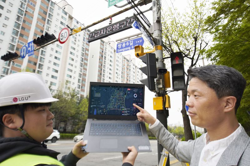 LG유플러스 관계자가 천안시에 설치된 긴급차량 출동 알림 전광판을 점검하고 있다. LG유플러스 제공