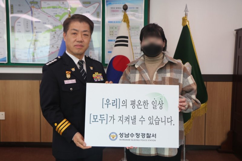 A씨(오른쪽)가 박영수 성남수정경찰서장과 기념 촬영하는 모습/사진=경기남부경찰청 제공,연합뉴스