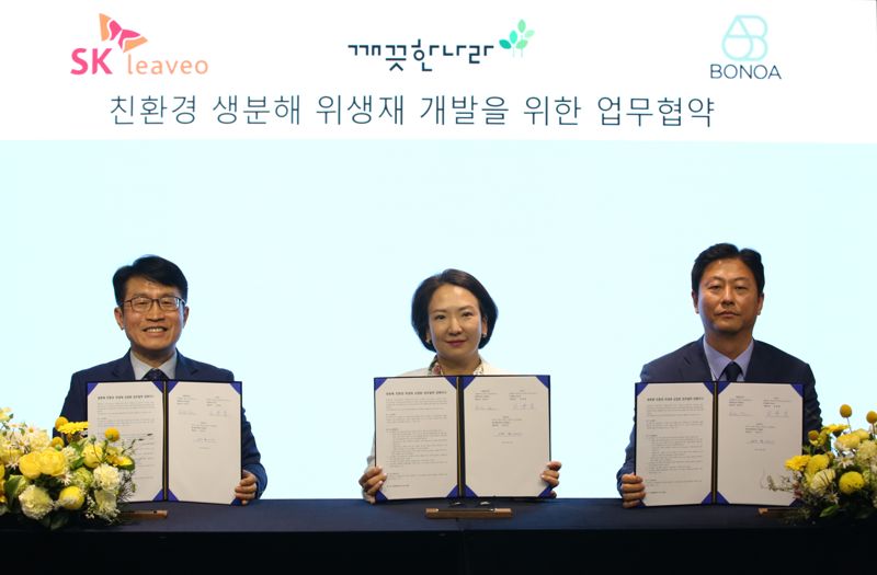 양호진 SK리비오 대표와 최현수 깨끗한나라 대표, 김용일 보노아 대표(왼쪽부터)가 지난 23일 '친환경 생분해 위생재 개발을 위한 업무협약'을 체결하고 협약서를 들어 보이고 있다. SKC 제공