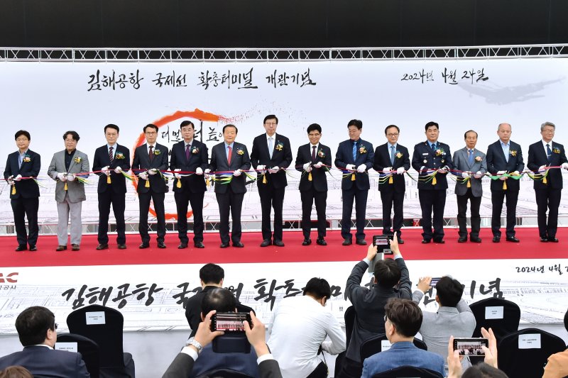 24일 김해공항 국제선 확장터미널 개관 기념식에서 참석자들이 테이프커팅을 하고 있다. 부산시 제공
