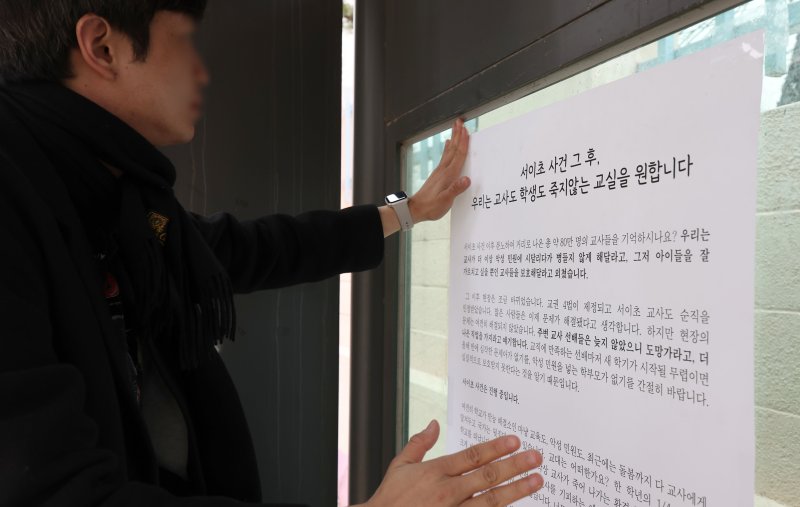 [서울=뉴시스] 김선웅 기자 = 2030 유권자네트워크(가칭) 소속 활동가가 지난달 22일 서울 서초구 서이초등학교 인근에서 익명의 예비 초등교사가 안전한 교실 만들기, 교권 보호, 청년들의 정치참여, 22대 국회의원 선거 투표 참여를 촉구하며 작성한 대자보를 붙이고 있다. 2024.03.22. mangusta@newsis.com