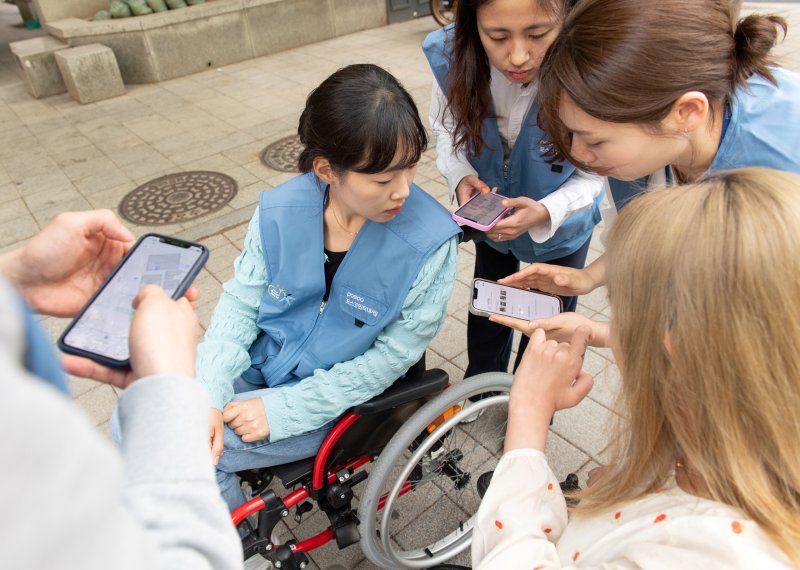 포스코인터내셔널 임직원들이 최근 휠체어를 타고 다니며 휠비(휠체어 전용 내비게이션) 앱에 적용될 위치 정보를 수집하고 있다. 포스코인터내셔널 제공