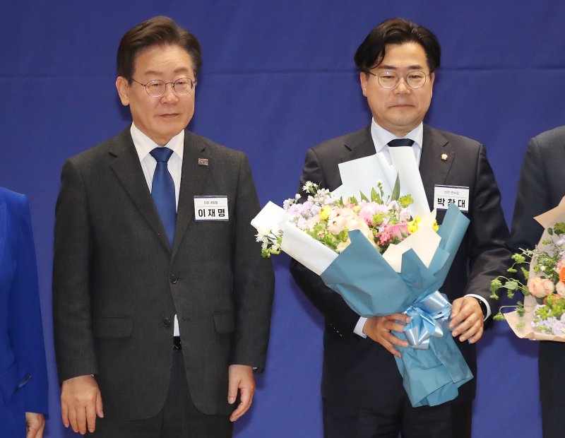 박찬대 신임 더불어민주당 원내대표(오른쪽)가 3일 오전 국회에서 열린 당선자총회에서 원내대표에 선출된 후 꽃다발을 들고 이재명 대표와 기념 촬영을 하고 있다. 뉴스1