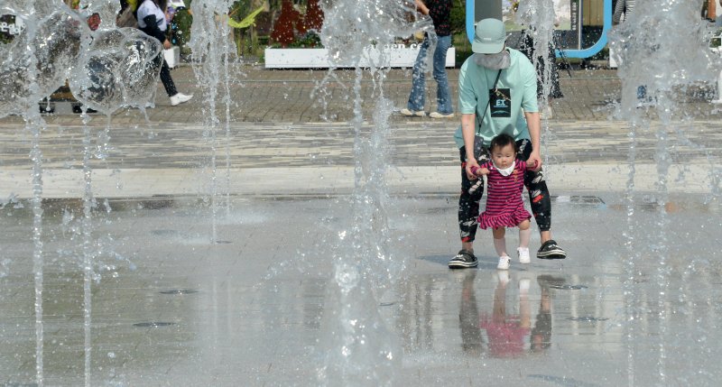 전북 전주시 전주월드컵경기장 광장 분수대를 찾은 한 가족이 물놀이를 하며 더위를 식히고 있다. 뉴시스