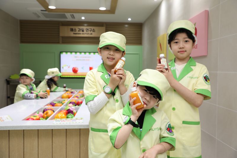 휴롬이 키자니아 서울에 마련한 채소과일 연구소에서 아이들이 직접 착즙한 주스를 들고 기념 촬영을 하고 있다. 휴롬 제공