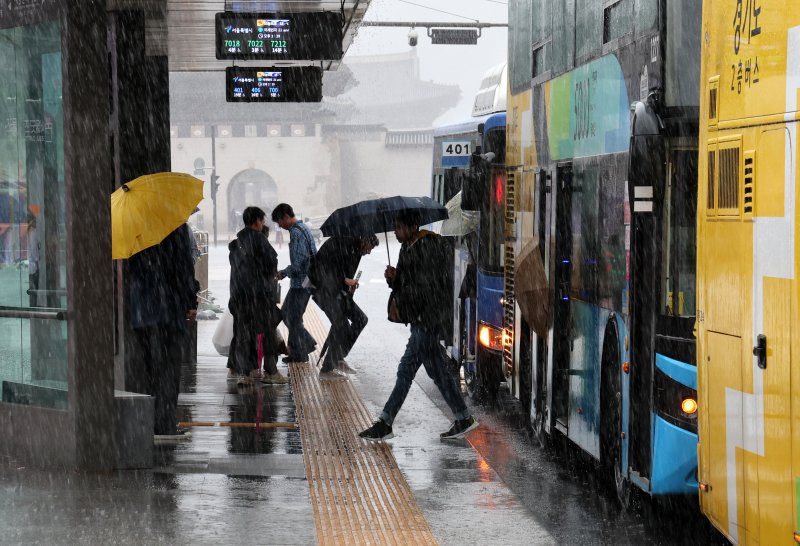 [서울=뉴시스] 배훈식 기자 = 전국에 많은 비가 내린 5일 오후 서울 종로구 광화문 광장에서 우산을 든 시민들이 버스를 타고 있다. 2024.05.05. dahora83@newsis.com