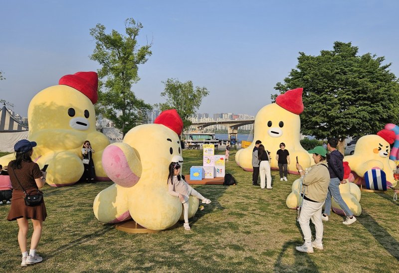 서울 여의도한강공원에서 개최된 야외 도서관 '책읽는 한강공원'을 찾은 시민들이 대형 무너 조형물로 구성된 '포토존'에서 기념 촬영을 하고 있다. LG유플러스 제공