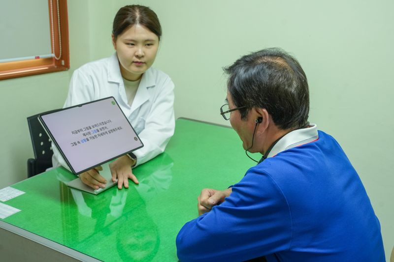 전기연구원 연구진이 안산 상록구노인복지관의 노인에게 '노인 친화형 대화 데이터 수집 기기'로 경도인지장애 조기 선별 검사를 하고 있다. 전기연구원 제공